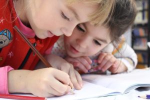 Zwei Kinder machen Hausaufgaben während der Betreuung beim Offenen Ganztag Angebot